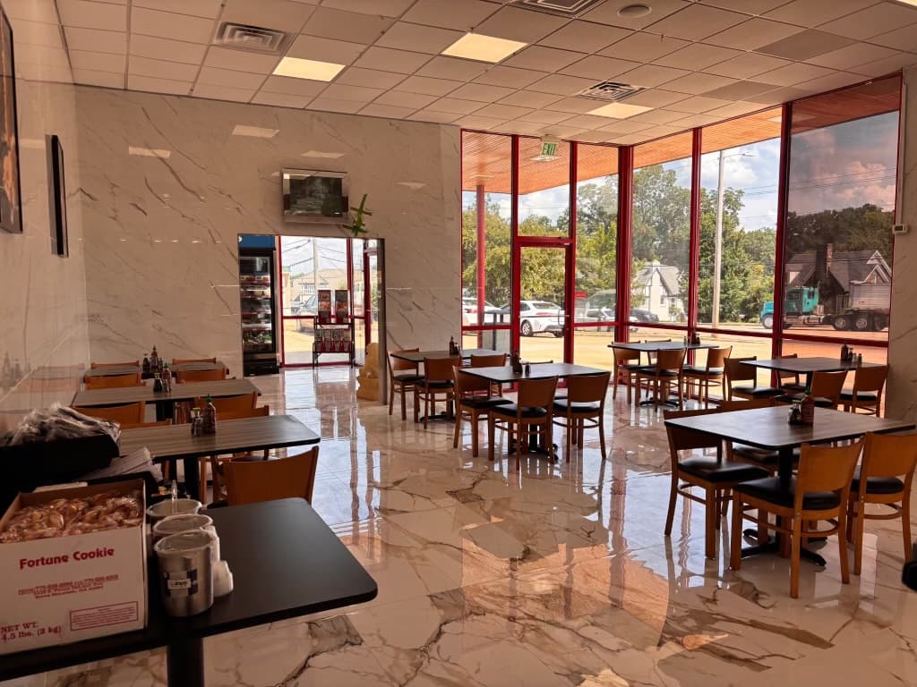 The remodeled dining room in Tupelo, with marble floors, wooden chairs and tables along a wall of windows